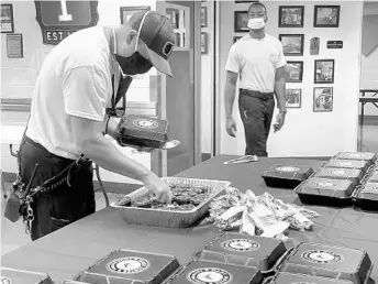  ?? ASHLEY PAPAGNI/OFD ?? Members of the Orlando Fire Department gathered to eat barbecue chicken and pork sandwiches, beans and mac n’cheese from Mission BBQ, provided by the Gary Sinise Foundation’s Central Florida Chapter,