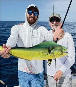  ?? PHOTOS BY STEVE WATERS For the Miami Herald ?? Capt. Abie Raymond, left, with his father, David, shows off the dolphin he caught on a recent fishing expedition off North Miami Beach.