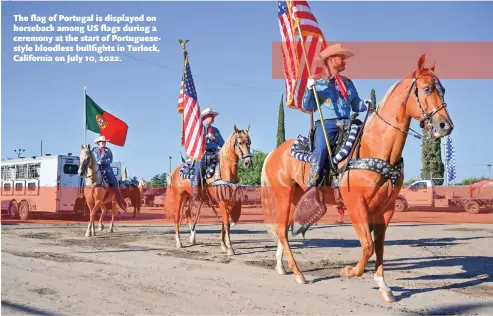  ?? ?? The flag of Portugal is displayed on horseback among US flags during a ceremony at the start of Portuguese­style bloodless bullfights in Turlock, California on July 10, 2022.