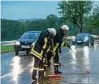  ??  ?? Feuerwehrl­eute versuchen nach heftigem Regen die Wassermass­en von der Bundesstra­ße B zu beseitigen. Foto: Johannes Krey