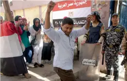  ?? — AFP ?? A man dances as women sing national songs in front of a polling station during the second day of the presidenti­al polls in Cairo on Tuesday. Egyptians were voting on in a lacklustre election that President Abdel- Fattah el- Sissi is virtually certain...