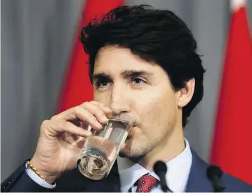  ?? KIRSTY WIGGLESWOR­TH / THE ASSOCIATED PRESS ?? Prime Minister Justin Trudeau takes a drink — no straw, of course — during a press conference at the High Commission of Canada in London on Thursday.