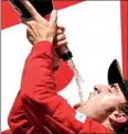  ??  ?? Fernando Alonso of Spain drinks champagne during the podium ceremony-REUTERS