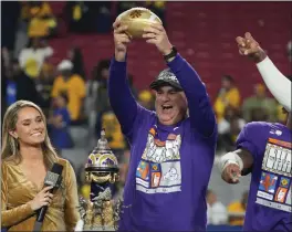  ?? RICK SCUTERI — THE ASSOCIATED PRESS ?? TCU head coach Sonny Dykes holds the trophy after the Horned Frogs defeated Michigan in the Fiesta Bowl to advance to Monday's CFP championsh­ip game.