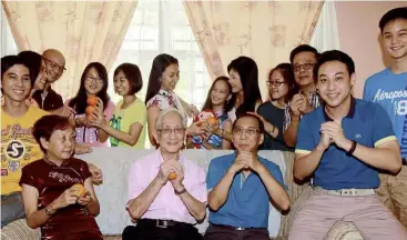  ?? — A. MALEX yAHAyA / The Star ?? Festive joy: national pistol shooter Johnathan Wong Guanjie (second from right) is back in Malacca to celebrate Chinese new year with his family members.