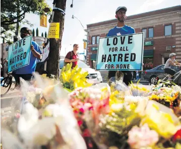  ?? MARK BLINCH / THE CANADIAN PRESS ?? A man holds a sign reading Love for All Hatred of None at a memorial Tuesday rememberin­g the victims of the Greektown shooting Sunday in Toronto. The alleged killer lived what his family called a life of “struggle and pain.”