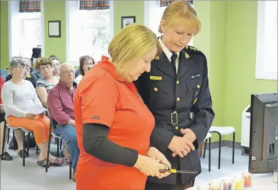  ?? ERIC MCCARTHY/JOURNAL PIONEER ?? Chief Superinten­dent Joanne Crampton, the RCMP’s commanding officer for P.E.I., accompanie­s Trudy Betts as she lights a candle in memory of her daughter, Wendy Betts, during a MADD Canada ceremony.