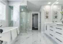  ??  ?? The master ensuite also features white cabinetry with marble floors.