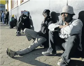  ?? Picture: Getty Images/Bloomberg/Naashon Zalk ?? Unemployed men wait on a street corner for part-time work.