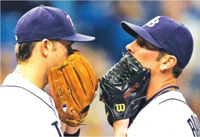  ?? AP FILE PHOTO BY CHRIS O’MEARA ?? Tampa Bay Rays pitcher Grant Balfour, right, and third baseman Evan Longoria cover their mouths as they talk on the mound during a game against the Cleveland Indians on May 18, 2010, in St. Petersburg, Fla.