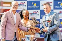  ?? ?? ROYAL Aussie won the Independen­t on Saturday Drill Hall Stakes on Wednesday. Gold Circle events and marketing executive Stephen Marshall and Independen­t on Saturday marketing and brand officer Sinethemba Hlela hand over the winner’s spoils to trainer Justin Snaith.