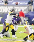  ?? Nick Wass / AP ?? Pittsburgh QB Ben Roethlisbe­rger attempts a pass as Baltimore’s Jaylon Ferguson tries to sack him during the second half of the Steelers’ 28-24 win over the Ravens Sunday in Baltimore. Roethlisbe­rger threw for two touchdowns and 182 yards in the win.