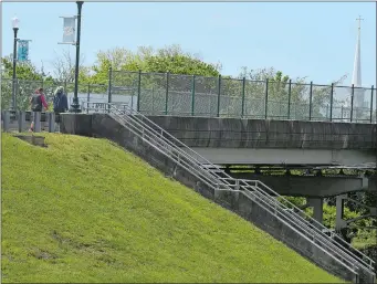  ?? SARAH GORDON/THE DAY ?? Walkers move across the Stonington viaduct on Thursday. There is a proposal to replace the bridge, which is the sole entry into Stonington Borough.