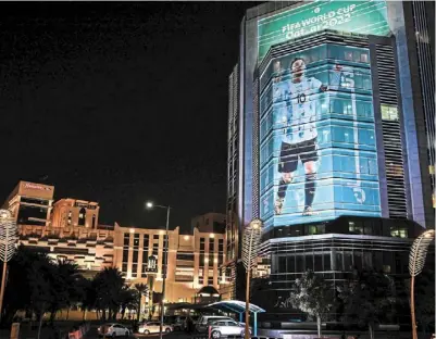  ?? — AFP ?? Beacon of hope: an image of argentina’s forward Lionel messi decorates a building’s facade in doha. Can messi shine and steer his team back on the trail for World Cup glory when they play mexico today?