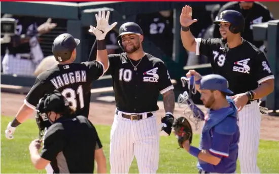  ?? ROSS D. FRANKLIN/AP ?? White Sox rookie Andrew Vaughn, who also grounded out sharply and walked, celebrates his three-run home run in the first inning Tuesday off Rangers right-hander Kohei Arihara (right photo) with Yoan Moncada (10) and Jose Abreu.