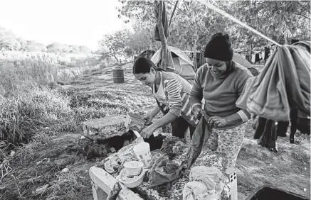  ?? Jerry Lara / Staff photograph­er ?? Hondurans Ana Hernandez, 25, left, and Vivian Flores, 30, do their laundry in the migrant camp in Matamoros, Mexico. The majority of the more than 2,200 migrants at the camp are awaiting their court dates with a U.S. immigratio­n judge.