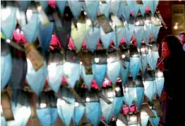  ?? — AP ?? A woman prays in front of lanterns to celebrate the New Year at Jogyesa Buddhist temple in Seoul on Sunday.