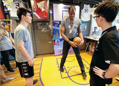  ?? PROVIDED TO CHINA DAILY ?? NBA Hall of Famer David Robinson teaches fans basketball skills at a promotiona­l event for the new NBA Champions-themed FamilyMart shop in Shanghai on Thursday.