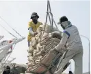  ?? /Reuters ?? Changing hands: Workers at Sunda Kelapa harbour in Jakarta arrange sacks of cement to be taken to Indonesia’s Sumatra island.