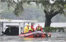  ?? AP PHOTO/PHELAN M. EBENHACK ?? First responders with Orange County Fire Rescue use an inflatable boat to rescue a resident from a home Thursday in the aftermath of Hurricane Ian in Orlando, Fla.