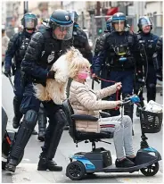  ?? REUTERS ?? Crowd: Officer helps woman during protests