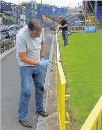  ??  ?? ●●Painting the Railway End at Edgeley Park