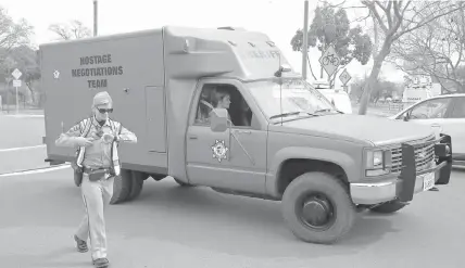  ?? ASSOCIATED PRESS ?? A sheriff's hostage negotiatio­n team passes a California highway patrol checkpoint at the Veterans Home of California in Yountville, California, where a gunman has taken hostages. Four, including the gunman, were later found dead inside the Veterans...