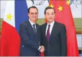 ?? WANG JING / CHINA DAILY ?? State Councilor and Foreign Minister Wang Yi (right) shakes hands with Philippine Foreign Affairs Secretary Alan Peter Cayetano before their meeting at the Diaoyutai State Guesthouse in Beijing on Wednesday.