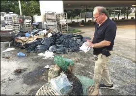  ?? AP PHOTO ?? Bobby Jucker, owner of Three Brothers Bakery, cleans up the storm damage at his bakery in Houston.