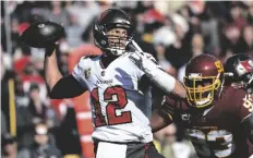  ?? AP PHOTO/MARK TENALLY ?? Tampa Bay Buccaneers quarterbac­k Tom Brady (12) throws under pressure from Washington Football Team defensive tackle Jonathan Allen (93) during the first half of an NFL football game, on Sunday in Landover, Md.