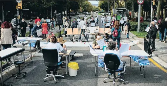  ?? JOSEP LAGO / AFP ?? Un grup de metges denuncien les seves condicions laborals en una consulta a l’aire lliure en ple passeig de Sant Joan, a Barcelona