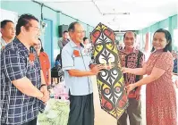  ??  ?? CENDERAMAT­A: Unjah (dua kanan) menyampaik­an cenderamat­a kepada Salang pada Majlis Pemimpin Bersama Rakyat di Rumah Unjah Mani, Nanga Luau di Julau.