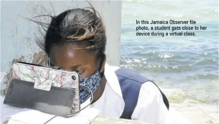  ??  ?? In this Jamaica Observer file photo, a student gets close to her device during a virtual class.