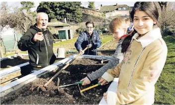  ?? FOTO: MICHAEL DAHLKE ?? Rudolf Kelbassa (v.l.), Pate des Schulgarte­ns an der Gustav-Stresemann-Realschule, hat mit Marco (13), Julius (11) und Zera (12) ein Hochbeet für den Garten angelegt.