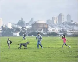  ?? Brian van der Brug Los Angeles Times ?? A FAMILY plays at Crissy Field in Golden Gate National Recreation Area. The biggest obstacle to residents staying in San Francisco is the high cost of housing.