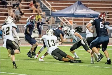  ?? Tim Godbee ?? Calhoun defenders swarm a Woodstock runner in an overwhelmi­ng 56-16 road win.