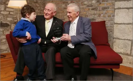  ??  ?? Johnny Giles presents the Specsavers Grandparen­t of the Year Award to Packie McGuinness, pictured with his grandson James.