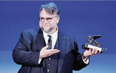  ??  ?? In trionfo
Il messicano Guillermo Del Toro subito dopo la premiazion­e