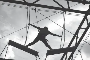  ?? CHEN ZEBING / CHINA DAILY ?? A participan­t grapples with the chains during an outward-bound program in Fangshan district, Beijing, this week.