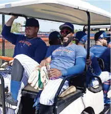  ?? ?? JUGADORES DE los Mets se trasladan en un carro de golf