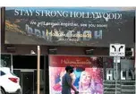  ??  ?? In this file photo a man in a mask walks past a sign near Madame Tussauds wax museum, one of the popular tourist attraction­s in Hollywood, California.