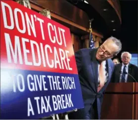  ?? MANUEL BALCE CENETA — ASSOCIATED PRESS ?? Senate Minority Leader Chuck Schumer of New York, followed by Sen. Bernie Sanders, I-Vt., look at a poster at the start of a news conference on Capitol Hill in Washington, urging Republican­s to abandon cuts to Medicare and Medicaid.