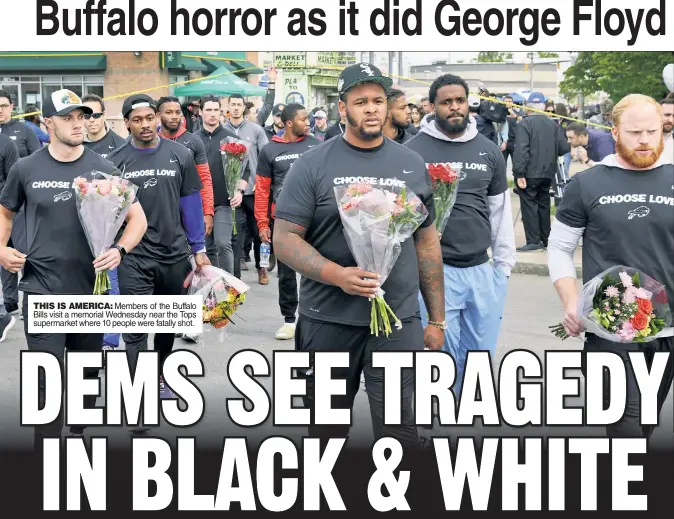  ?? ?? THIS IS AMERICA: Members of the Buffalo Bills visit a memorial Wednesday near the Tops supermarke­t where 10 people were fatally shot.