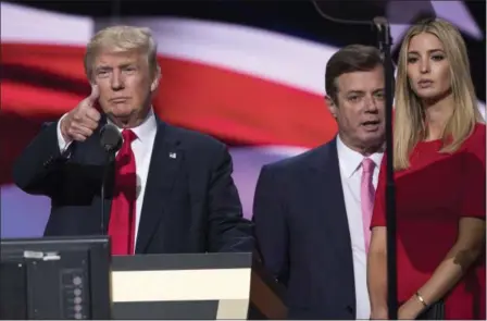  ?? EVAN VUCCI — THE ASSOCIATED PRESS ?? In this photo taken then-Trump Campaign manager Paul Manafort stands between the then-Republican presidenti­al candidate Donald Trump and his daughter Ivanka Trump during a walk through at the Republican National Convention in Cleveland.