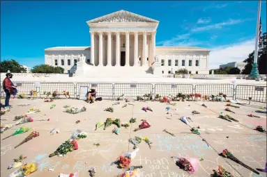  ?? Jose Luis Magana / AFP via Getty Images ?? Messages and flowers are left outside of the U.S. Supreme Court in memory of Justice Ruth Bader Ginsburg, in Washington, DC, on Saturday. Ginsburg died Friday, opening a crucial vacancy on the high court expected to set off a pitched political battle at the peak of the presidenti­al campaign.