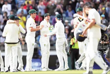  ?? GREG WOOD/AFP ?? Australia players celebrate taking the Ashes series after winning the third Test against England at the WACA Ground in Perth yesterday.