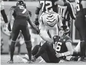  ?? BOB SELF Florida Times-Union ?? Jaguars receiver Zay Jones (7) and Bengals defensive end Trey Hendrickso­n try to help up Jaquars QB Trevor Lawrence after he hurt his right ankle Monday night.