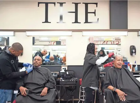  ?? COURTNEY HERGESHEIM­ER/COLUMBUS DISPATCH ?? From left: Brenton Newton, a student at the Ohio State College of Barber Styling in Whitehall, works on Yosef Chakle while fellow student Jasmine Craig cuts the hair of Frank Rollins.