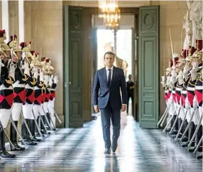  ??  ?? French President Emmanuel Macron walks through the Galerie des Bustes.