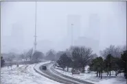  ?? ASSOCIATED PRESS FILE PHOTO ?? The downtown Tulsa skyline is barely visible with the snow falling in this 2020 photo. A cold front stretched from Dallas to Oklahoma City to central Kansas on Wednesday.